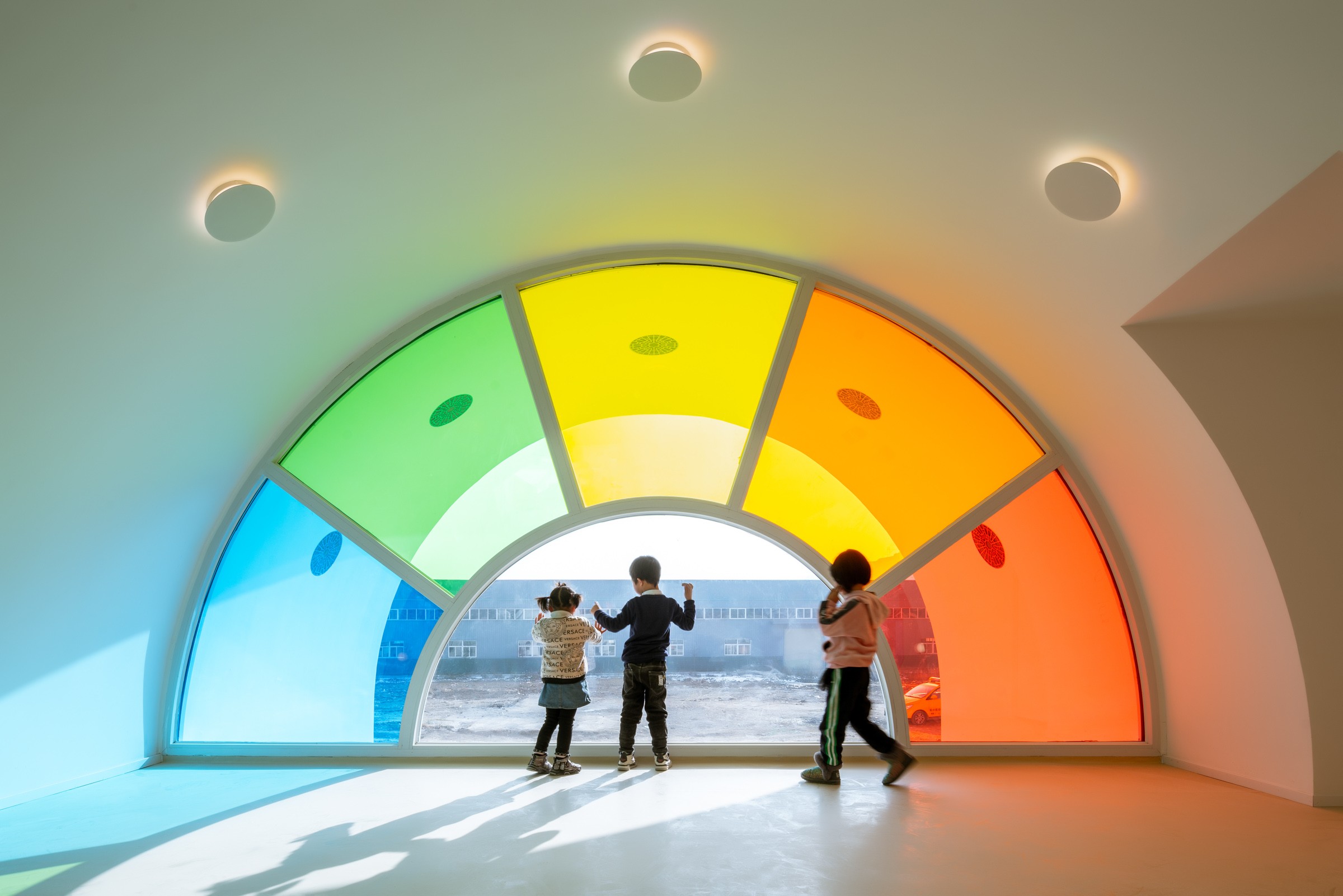 Emblem design for Madame FC depicting an M monogram in a circle with the words "Madame FC EST. 2003" inside on top of a background image of a soccer stadium.