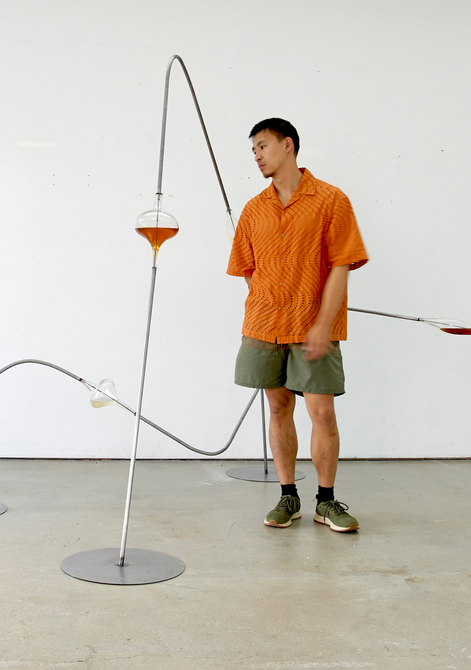 Portrait of a man with brown hair and glasses on a flat gray background.